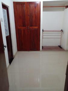 a room with a wooden door and a tiled floor at Minsara Villa in Hikkaduwa