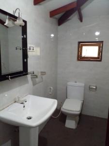 a bathroom with a white toilet and a sink at Minsara Villa in Hikkaduwa
