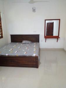 a bedroom with a bed and a mirror on the wall at Minsara Villa in Hikkaduwa