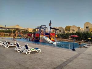a pool with chairs and a water park at British style in Makadi Heights in Hurghada