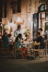 Hotel I Cinque Balconi في سانتا مارينا سالينا: مجموعة من الناس يجلسون على طاولة في مطعم