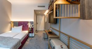 - une chambre avec un lit et un bureau dans l'établissement PLAZA Premium München, à Munich