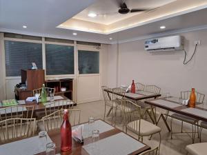 a dining room with tables and chairs and a projector at Hotel MK Grand in Varanasi