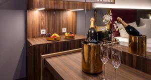 Zimmer mit 2 Flaschen Champagner und 2 Gläsern in der Unterkunft PLAZA Premium München in München