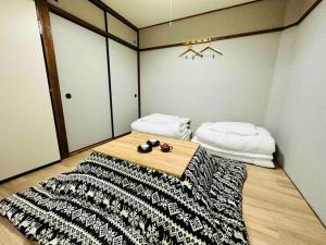 大阪市にある205gblhouse,黒門市場がすぐ目の前,徒歩30秒,大阪人気の観光エリアへ徒歩圏内道頓堀徒歩7分,南海難波駅徒歩6分のベッド1台、テーブル(ラグ付)