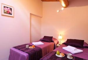 CarlazzoにあるVilla Isella - Mansardaの紫色のベッドカバーが備わる客室のベッド2台