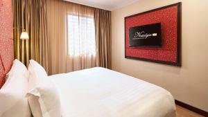 sypialnia z białym łóżkiem i oknem w obiekcie Nostalgia Hotel w Singapurze