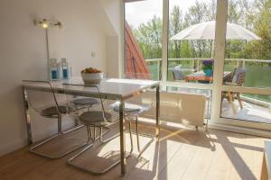 d'un balcon et d'une salle à manger avec une table et des chaises. dans l'établissement Urlaubsfeeling-in-der-Captains-Suite-App-18, à Timmendorfer Strand