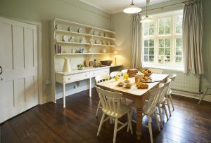 een keuken met een tafel en stoelen en een eetkamer bij The Old Rectory - Norfolk in North Tuddenham