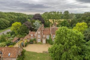 an aerial view of an old house with trees at The Old Rectory - Norfolk in North Tuddenham