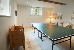 uma mesa de pingue-pongue numa sala de estar com uma mesa em The Old Rectory - Norfolk em North Tuddenham