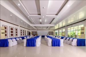 un gran salón de banquetes con mesas y sillas azules y blancas en Magsaysay Hillside Resort powered by Cocotel, 