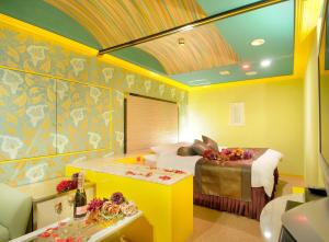 a room with a bed and a table with flowers on it at HOTEL LOVE IKUTAMA -Adult Only in Osaka +24 photos