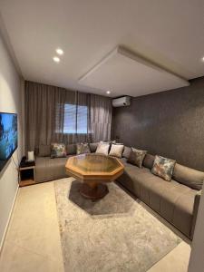 uma sala de estar com um sofá e uma mesa de centro em Appartement la Ville Haute em Kenitra