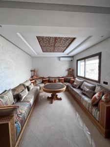 uma sala de estar com um sofá e uma mesa em Appartement la Ville Haute em Kenitra