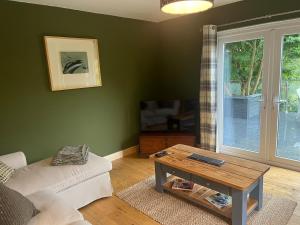 a living room with a couch and a coffee table at Erw Fair in Arthog