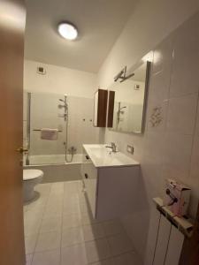 uma casa de banho branca com um lavatório e um WC em Casa Vacanze Fiore em Omegna
