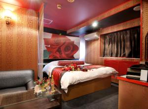 a bedroom with a bed and a chair in it at HOTEL LOVE IKUTAMA -Adult Only in Osaka