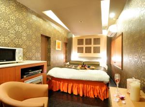 1 dormitorio con cama y mesa con copa de vino en HOTEL LOVE IKUTAMA -Adult Only, en Osaka