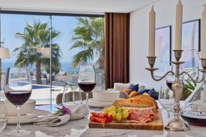 einen Tisch mit Weingläsern und einen Teller mit Essen in der Unterkunft Luxury stay in Villa Capellania. in Benalmádena