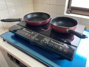 two pots and pans sitting on top of a stove at Best Shinjuku Modern Full-furnished Family size Apartment3 ONLY 2min to Shinjuku by Train in Tokyo