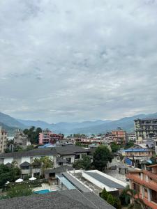 a city with buildings and mountains in the background at Hotel Point Pokhara in Pokhara