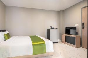 1 dormitorio con 1 cama y TV de pantalla plana en iCheck inn Darisa Ngamwongwan, en Ban Bang Khen (1)