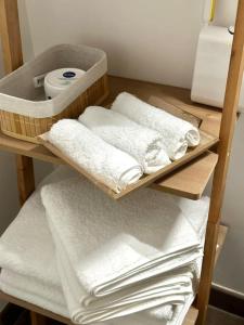 - un bouquet de serviettes sur une étagère dans une salle de bains dans l'établissement Perle rare « Le Cosy de CDG », au Blanc-Mesnil