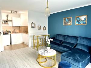 a living room with a blue couch and a table at Perle rare « Le Cosy de CDG » in Le Blanc-Mesnil