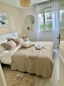 ein Schlafzimmer mit einem Bett mit zwei Schuhen drauf in der Unterkunft Perle rare « Le Cosy de CDG » in Le Blanc-Mesnil