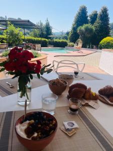 un tavolo ricoperto di cibo e un vaso di fiori di Villa Belvedere Versilia - Villa con tre camere, cucina, sala, giardino con piscina e vista - 7 posti letto a Camaiore