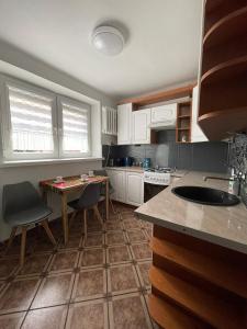 a kitchen with white cabinets and a table and chairs at Apartament na Piaskach in Ostrowiec Świętokrzyski