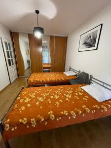 a bedroom with two beds with orange blankets at Apartament na Piaskach in Ostrowiec Świętokrzyski