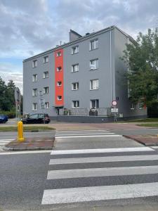 a large building on a street with a crosswalk at Apartament na Piaskach in Ostrowiec Świętokrzyski