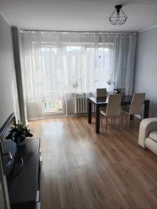 een woonkamer met een tafel en stoelen en een bank bij Super mieszkanie 3-pokoje in Bielawa