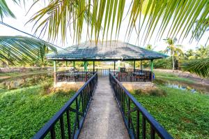 una pasarela que conduce a un cenador en un parque en Magsaysay Hillside Resort powered by Cocotel, 