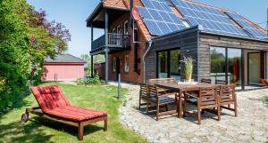 a patio with a table and chairs and a house with solar panels at Villa Agni in Dänschendorf