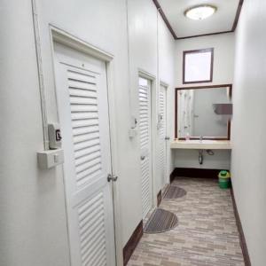 een hal met een badkamer met witte deuren en een wastafel bij กาลครั้งหนึ่ง ณ เชียงคาน (Once Upon A time) in Chiang Khan