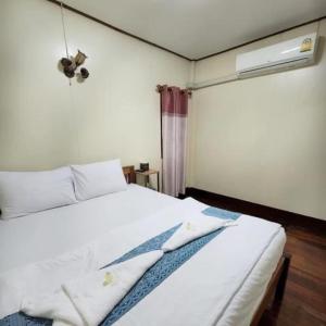 1 dormitorio con 1 cama blanca y ventilador en กาลครั้งหนึ่ง ณ เชียงคาน (Once Upon A time), en Chiang Khan