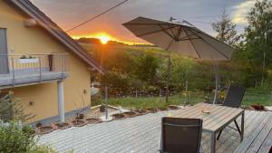 un patio con sombrilla, mesa y sillas en Ferienwohnung im Erzgebirge, en WeiÃŸbach