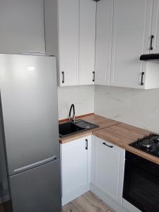 een witte keuken met een wastafel en een koelkast bij Super mieszkanie 3-pokoje in Bielawa