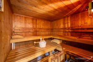 an empty wooden sauna with a bucket in it at Turmhotel Victoria Davos in Davos