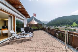 a balcony with chairs and a view of a mountain at Turmhotel Victoria Davos in Davos