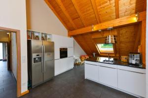 een keuken met roestvrijstalen apparatuur en een houten plafond bij Ferienwohnung im Erzgebirge in WeiÃŸbach