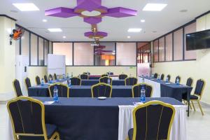 a conference room with blue tables and yellow chairs at Two Oceans Hotel Voi in Voi
