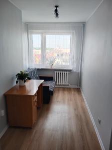 een lege woonkamer met een bank en een raam bij Super mieszkanie 3-pokoje in Bielawa