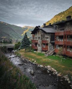 una casa en una colina junto a un río en AC Apartaments Vall d'Incles, en Incles