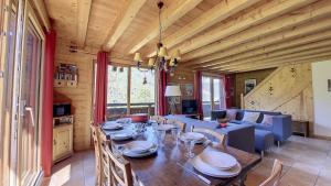 a dining room with a table and a couch at Chalet MON FRERE in Le Biot