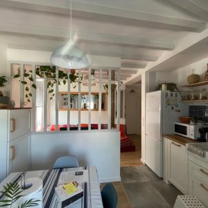 a kitchen with white cabinets and a white refrigerator at LA CHOUETTE DU LAC MARION in Biarritz