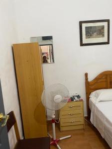 Habitación con 1 dormitorio con ventilador junto a la cama en Pensión Teruel, en Barcelona